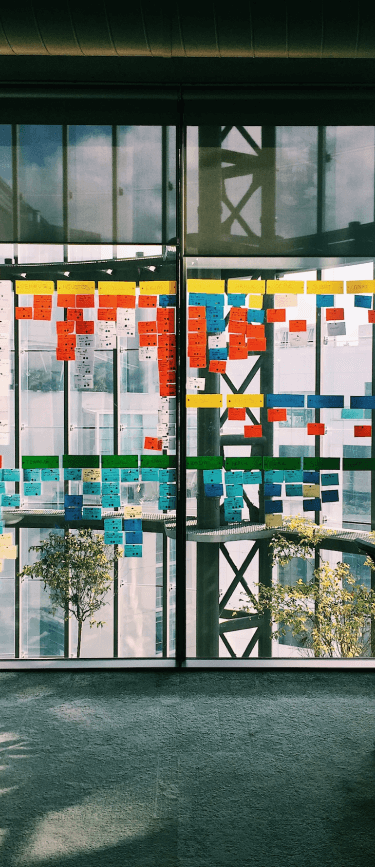 Oficina corporativa con post-it en la ventana de vidrio de Xauxa